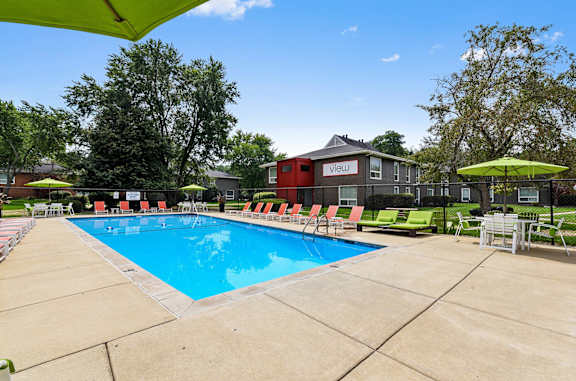 our apartments offer a swimming pool with chairs and umbrellas at The View Apartments St Charles, St Charles, 60174