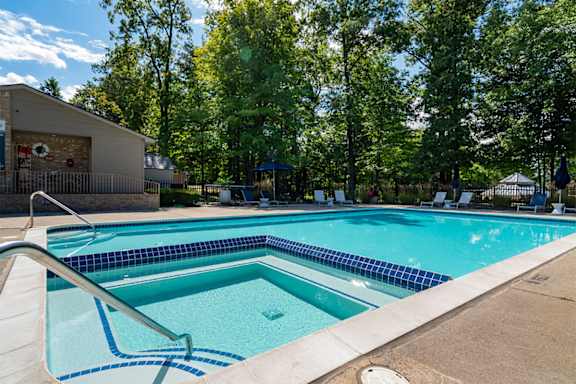 our apartments have a swimming pool and a patio with chairs  at Ascent at Farmington Hills, Michigan, 48331