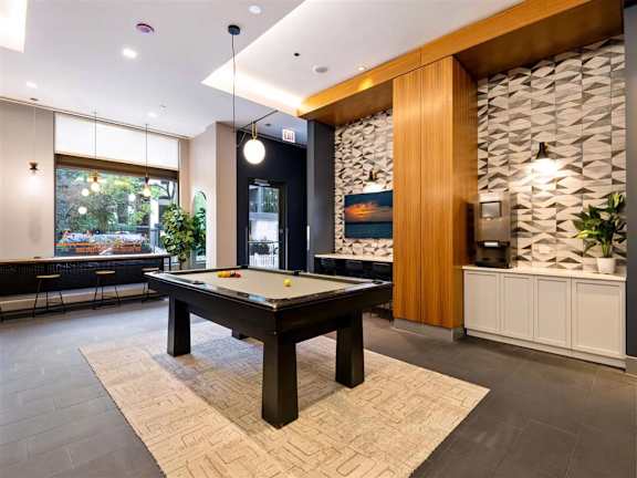 a pool table in a game room with a bar