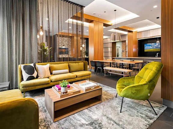 a living room with a yellow couch and a green chair