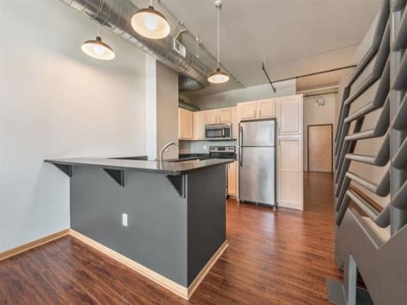 A kitchen area with a counter and a refrigerator.