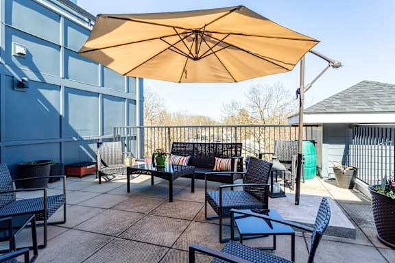 a patio with tables and chairs and an umbrella