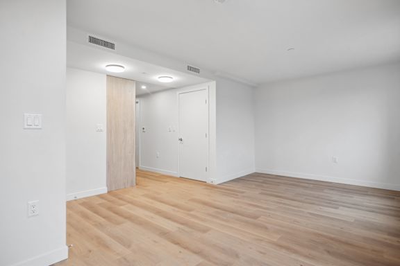 A room with a wooden floor and a white door.