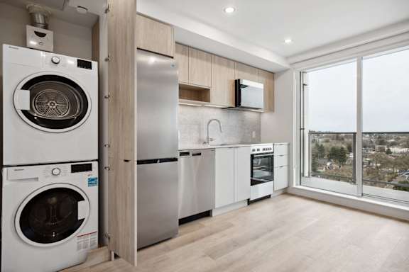 A modern kitchen with a washing machine and a refrigerator.