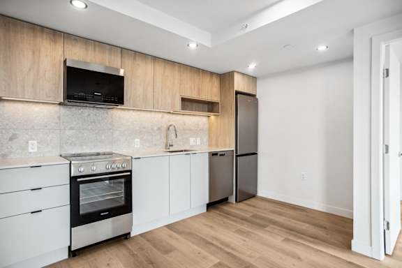 A modern kitchen with wooden cabinets and stainless steel appliances.