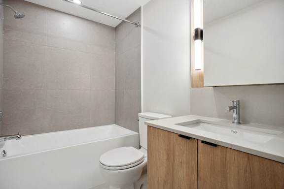 A white bathroom with a toilet, sink, and tub.