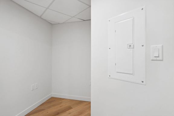A white door with a light switch on the wall.