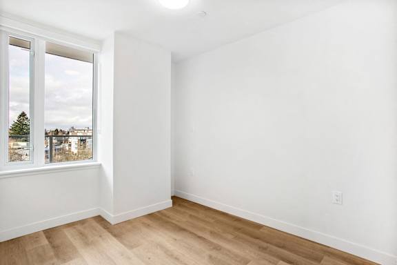 A room with a window overlooking a residential area.