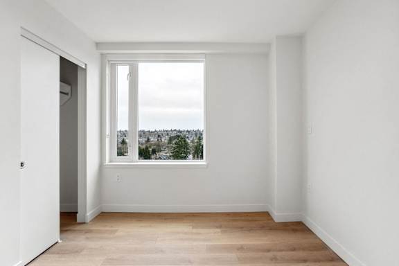 A room with a large window overlooking a tree-filled landscape.