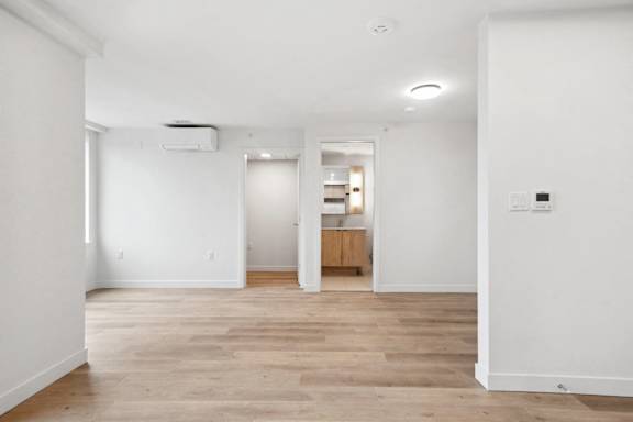 A room with wooden flooring and white walls.