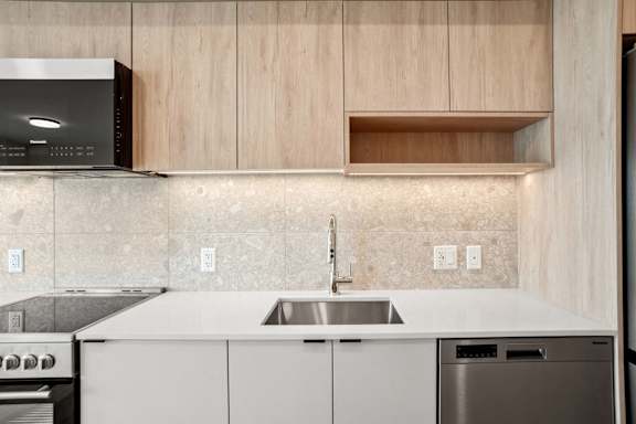 A modern kitchen with a stainless steel dishwasher and a microwave above the stove.