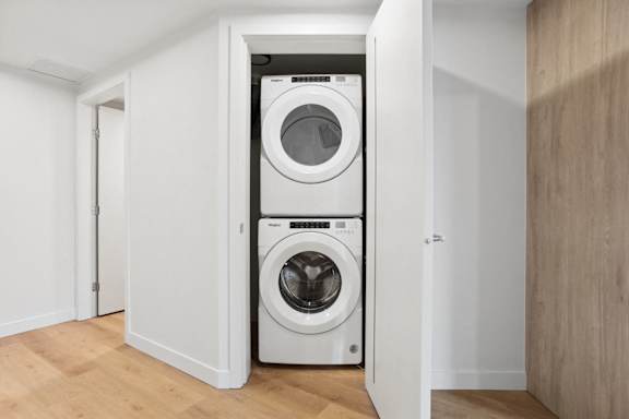 A white washing machine is in a small room.