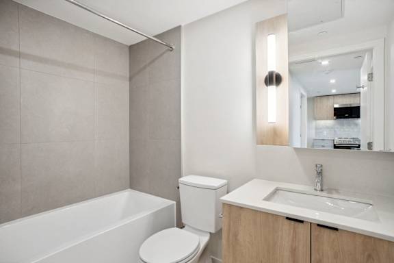 A white toilet sits next to a white sink in a modern bathroom.