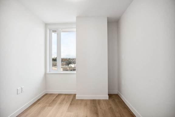 A room with a window and wooden floors.