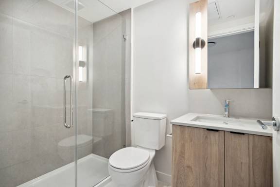 A white toilet sits next to a sink in a modern bathroom.