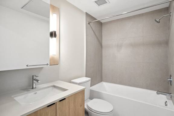 A white bathroom with a sink, toilet, and bathtub.