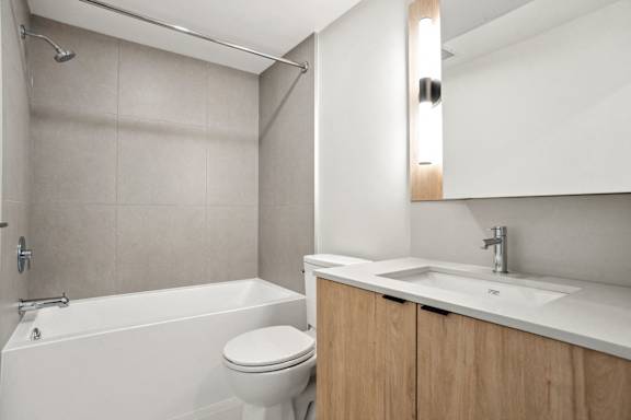 A white bathroom with a toilet, sink, and bathtub.