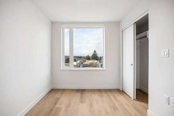 A room with a large window and wooden flooring.