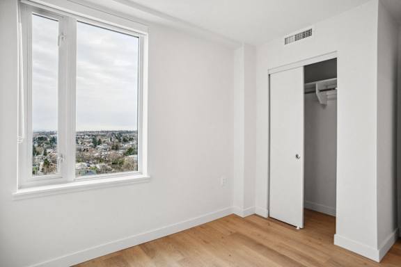 A room with a view of a town through a window.