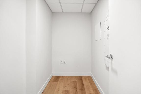 A white room with a door and a light switch.