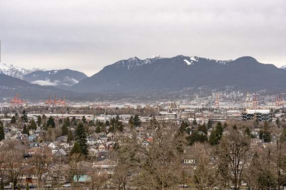 A cityscape with snow-capped mountains in the background.