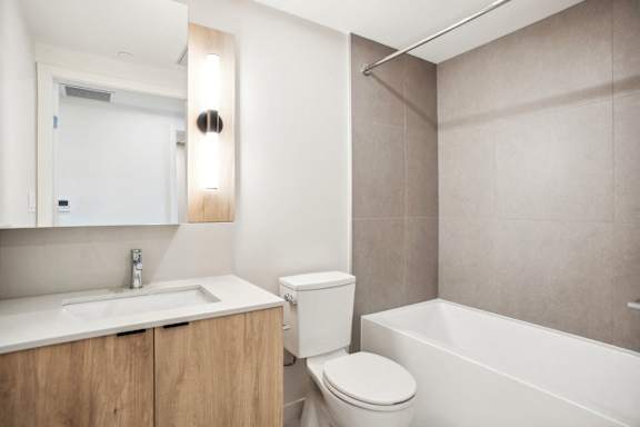 A white toilet sits next to a sink in a modern bathroom.