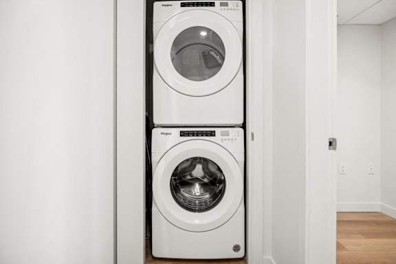 A white front load washing machine is on top of a white top load washing machine.