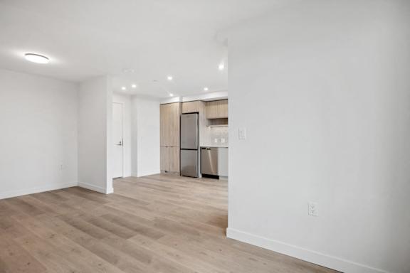 A kitchen area with a refrigerator, sink, and cabinets.