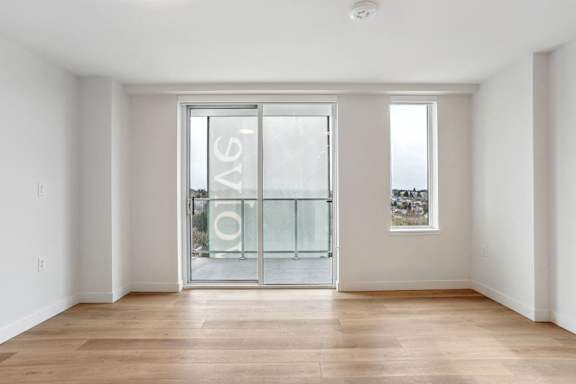 A room with a glass door and a wooden floor.