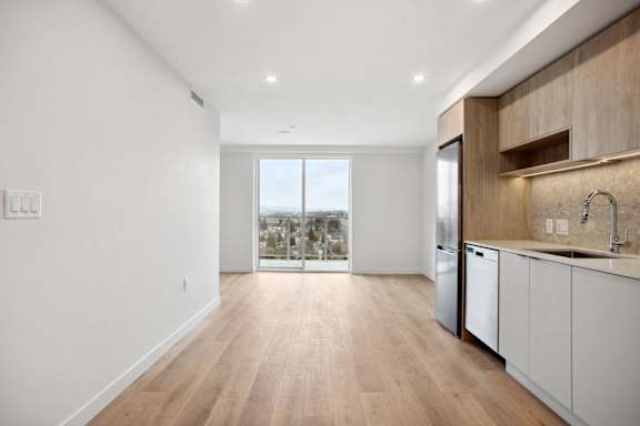 A kitchen with white cabinets and a wooden counter top.