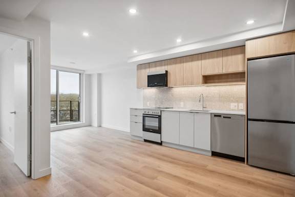 A modern kitchen with wooden cabinets and stainless steel appliances.