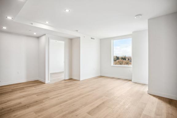 A room with wooden flooring and white walls.