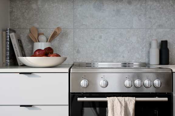 A white oven with a towel hanging on it.