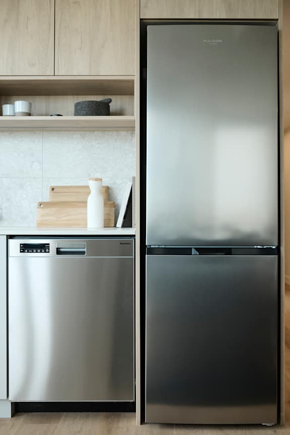 A stainless steel dishwasher and refrigerator in a kitchen.