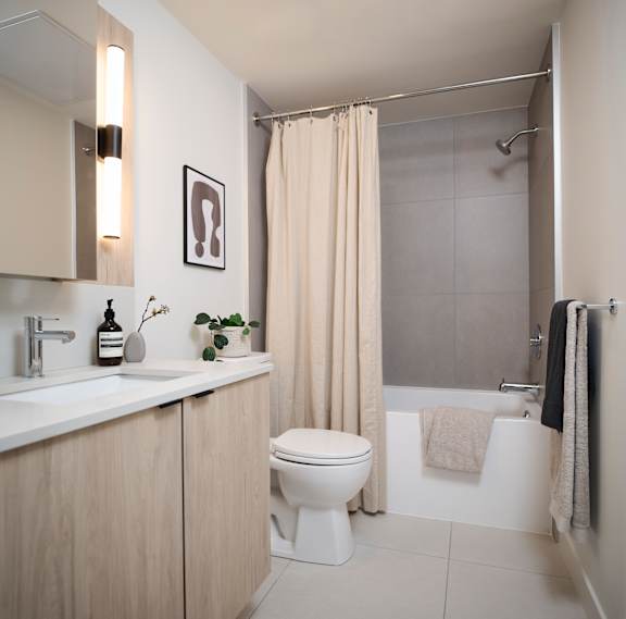 A bathroom with a toilet, sink, and shower.