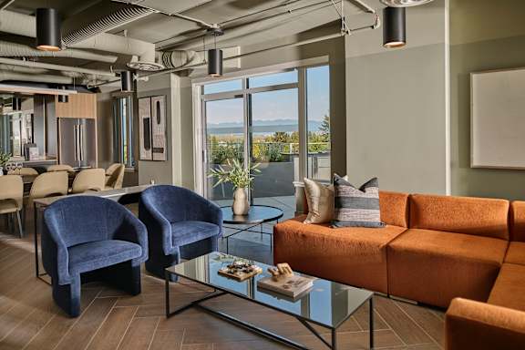 A living room with a blue chair and orange couch.