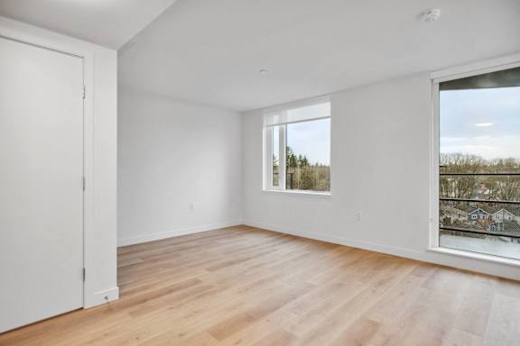 A room with a window and a wooden floor.