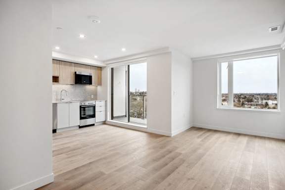 A modern kitchen with wooden floors and white walls.