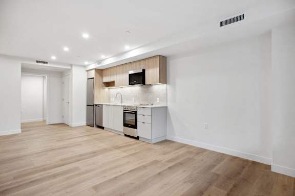A kitchen with white cabinets and a wooden countertop.