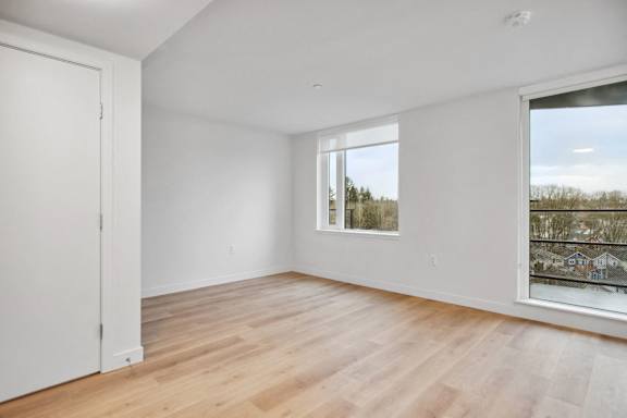 A room with a window and a wooden floor.