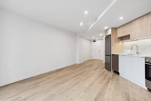 A kitchen with wooden floors and white walls.