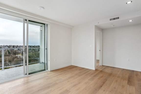 A room with a view of a cityscape through a glass door.