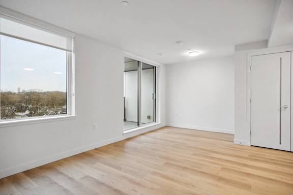 A room with a large window and wooden flooring.