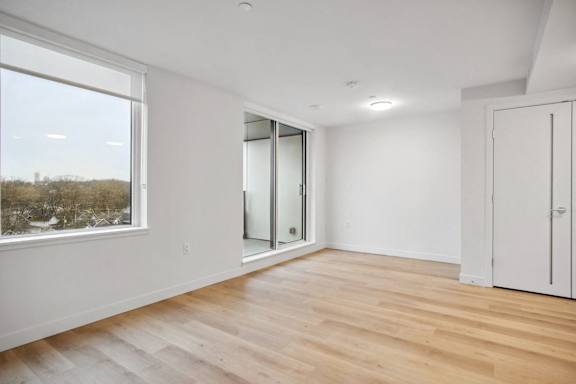 A room with a large window and wooden flooring.