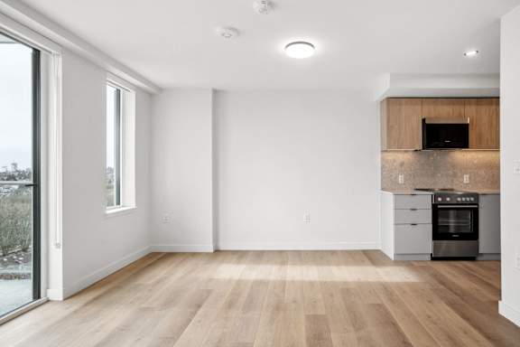 A modern kitchen with wooden floors and a stainless steel oven.