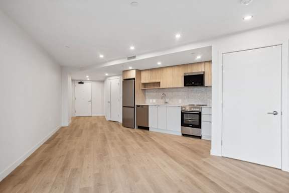 A kitchen with white cabinets and a wooden floor.