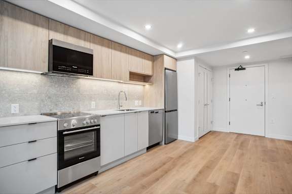 A modern kitchen with wooden cabinets and stainless steel appliances.