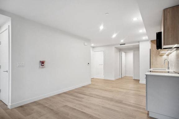 A kitchen area with a white wall and a wooden counter.