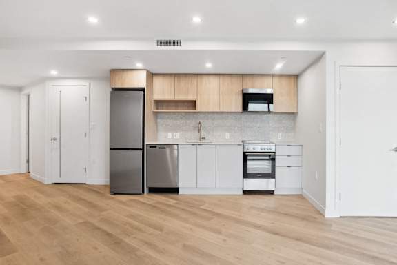 A kitchen with wooden floors and white walls.