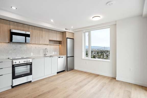 A modern kitchen with wooden cabinets and stainless steel appliances.